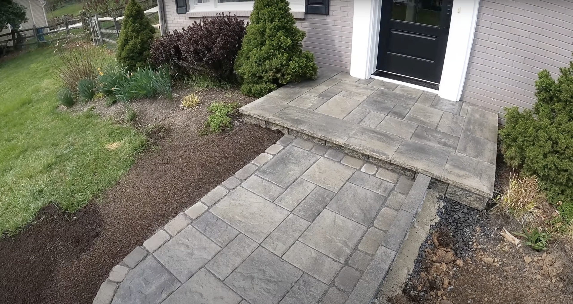 Stamped Concrete Patio - Natural stone pattern with elegant residential design Beautiful stamped concrete patio with natural stone pattern near residential home entrance